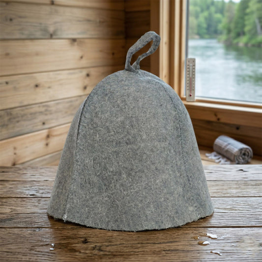 Gray felted hat on a wooden surface with a window view of water and trees.