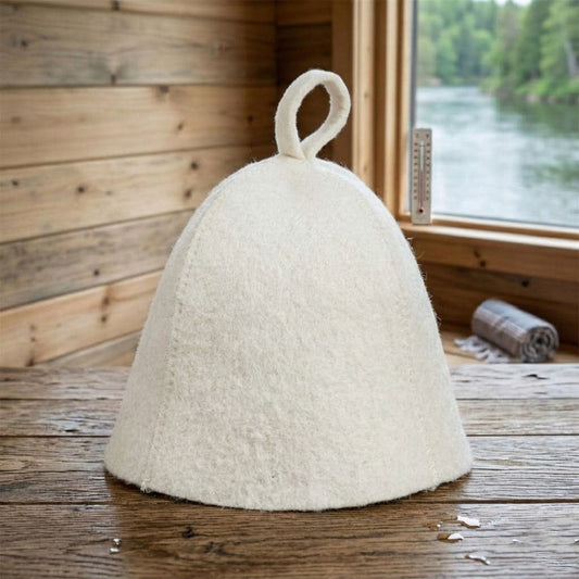 White wool sauna hat placed on wooden bench in sauna interior with window view