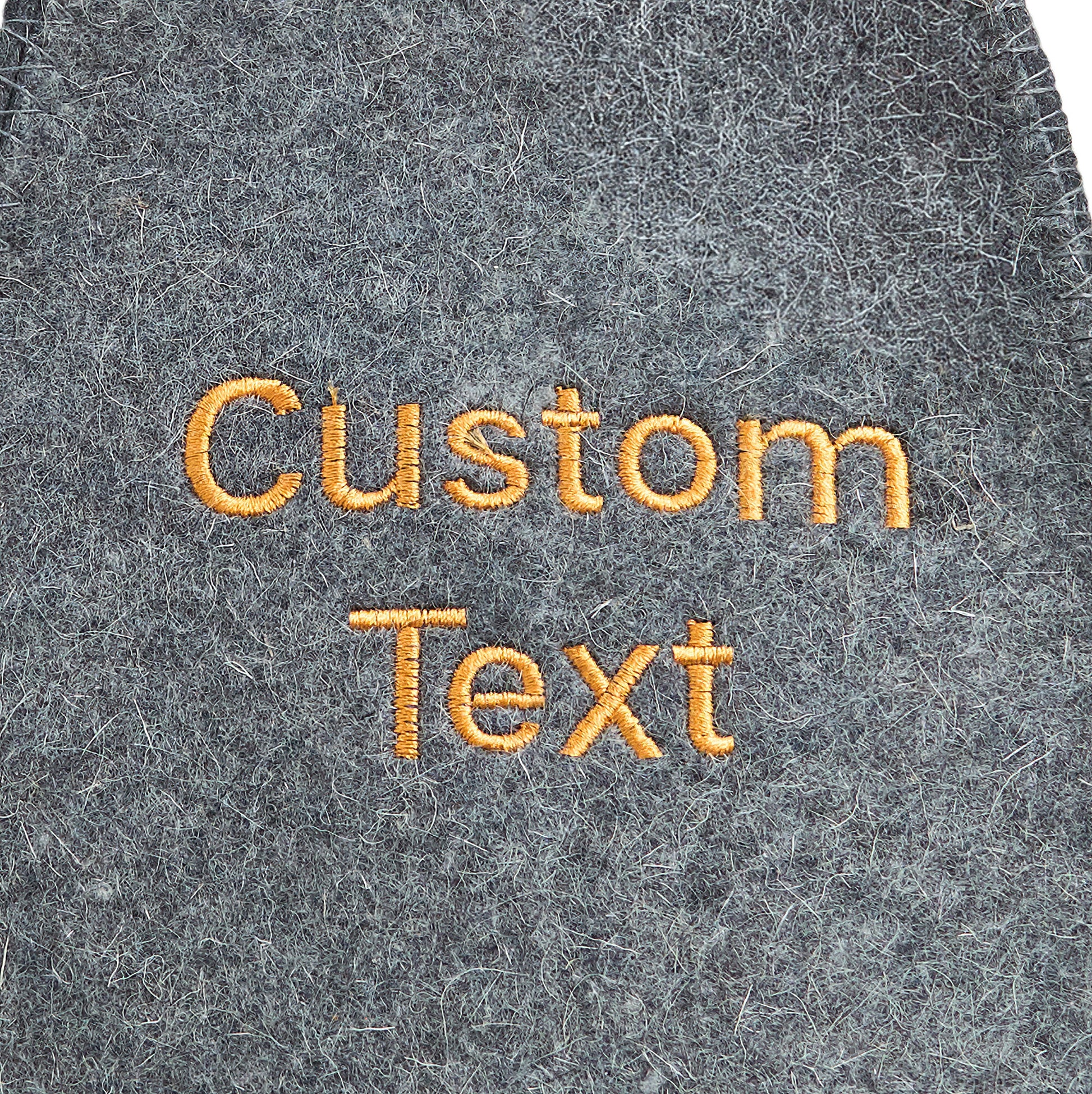 Close-up of custom embroidered text on gray wool felt sauna hat