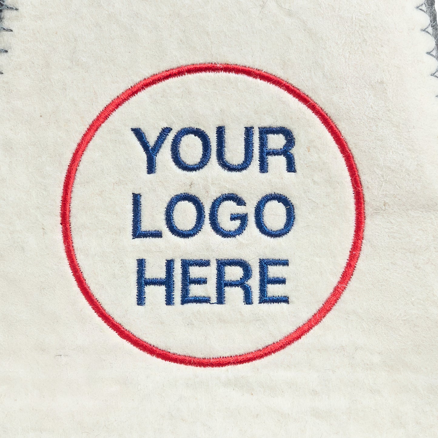 Close-up of custom logo embroidery on white wool sauna hat