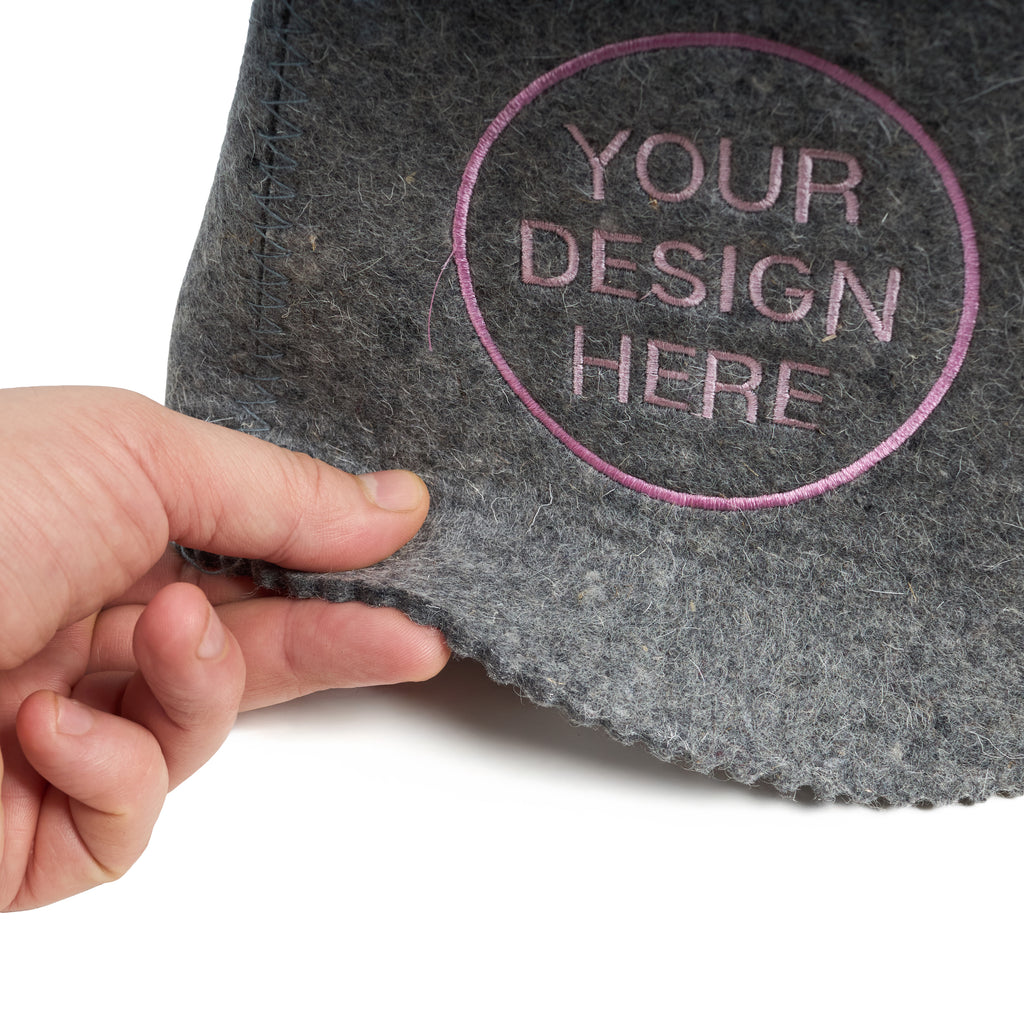 Gray felt with 'Your Design Here' text and a hand holding it on a white background