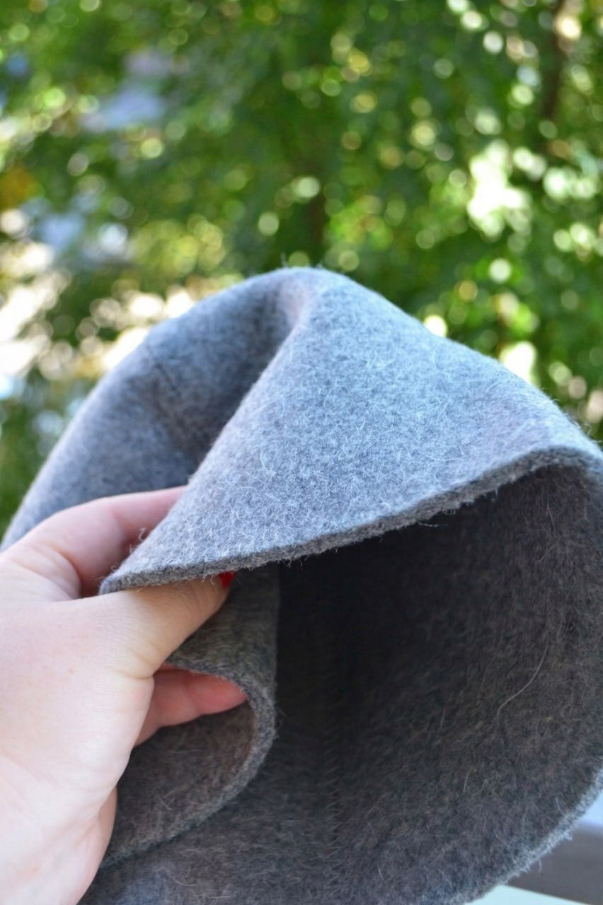 gray wool sauna hat soft felt close-up held by hand outdoors