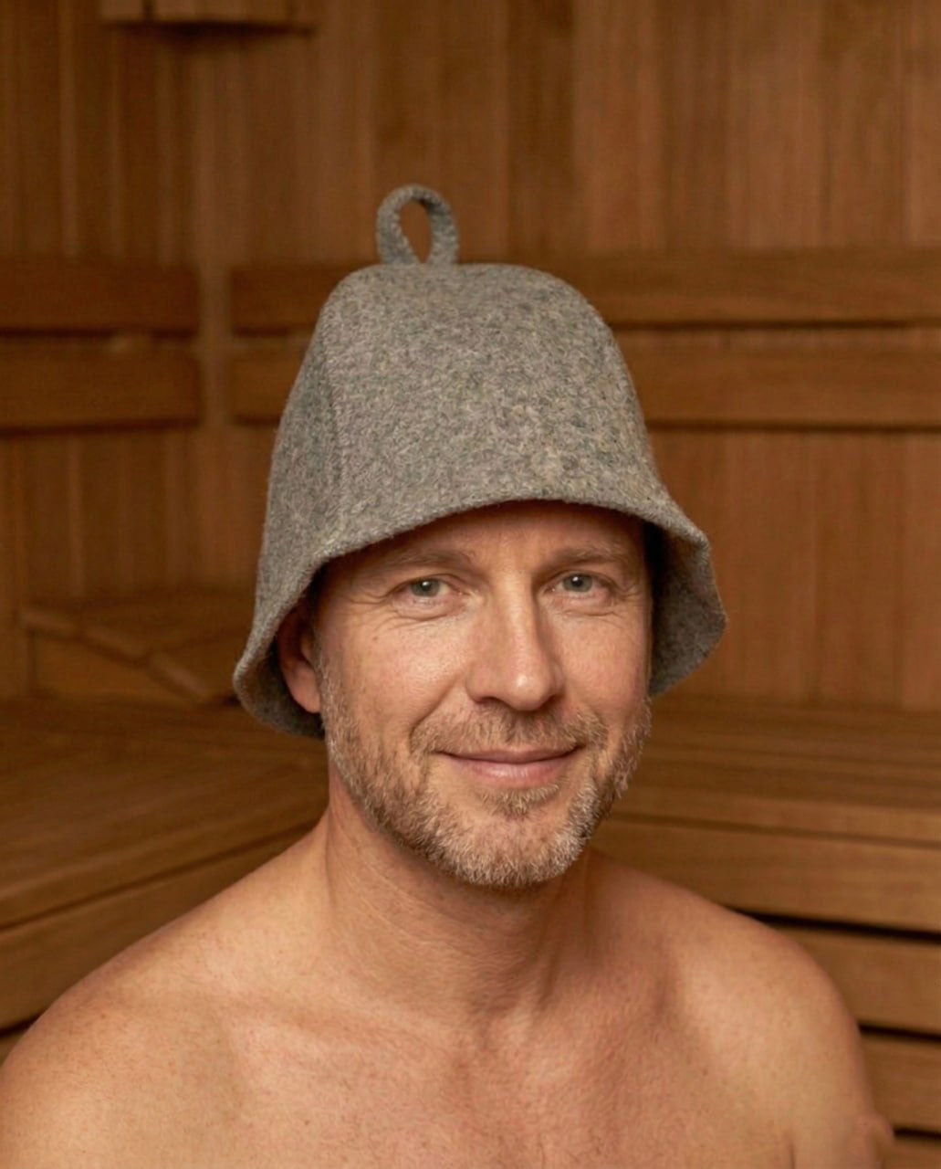 gray wool sauna hat worn by man in wooden sauna interior