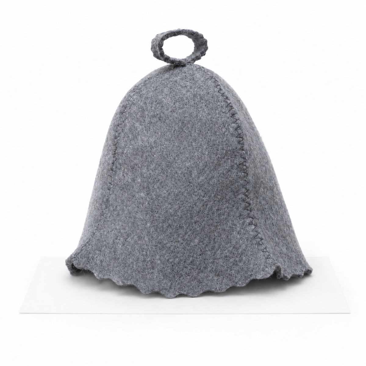 Natural gray wool sauna hat in a classic bell shape with visible stitched seams, scalloped bottom edge, and hanging loop at the top, shown from the front on a white background