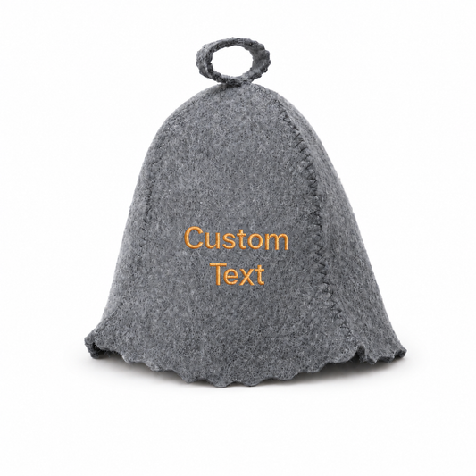 Gray wool sauna hat with orange custom text embroidery, classic bell shape, visible stitched seams, scalloped edge, and hanging loop at the top