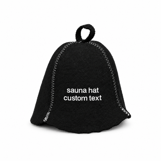 Black wool felt sauna hat with white custom text embroidery, white contrast stitching, and a hanging loop, shown on a clean white background