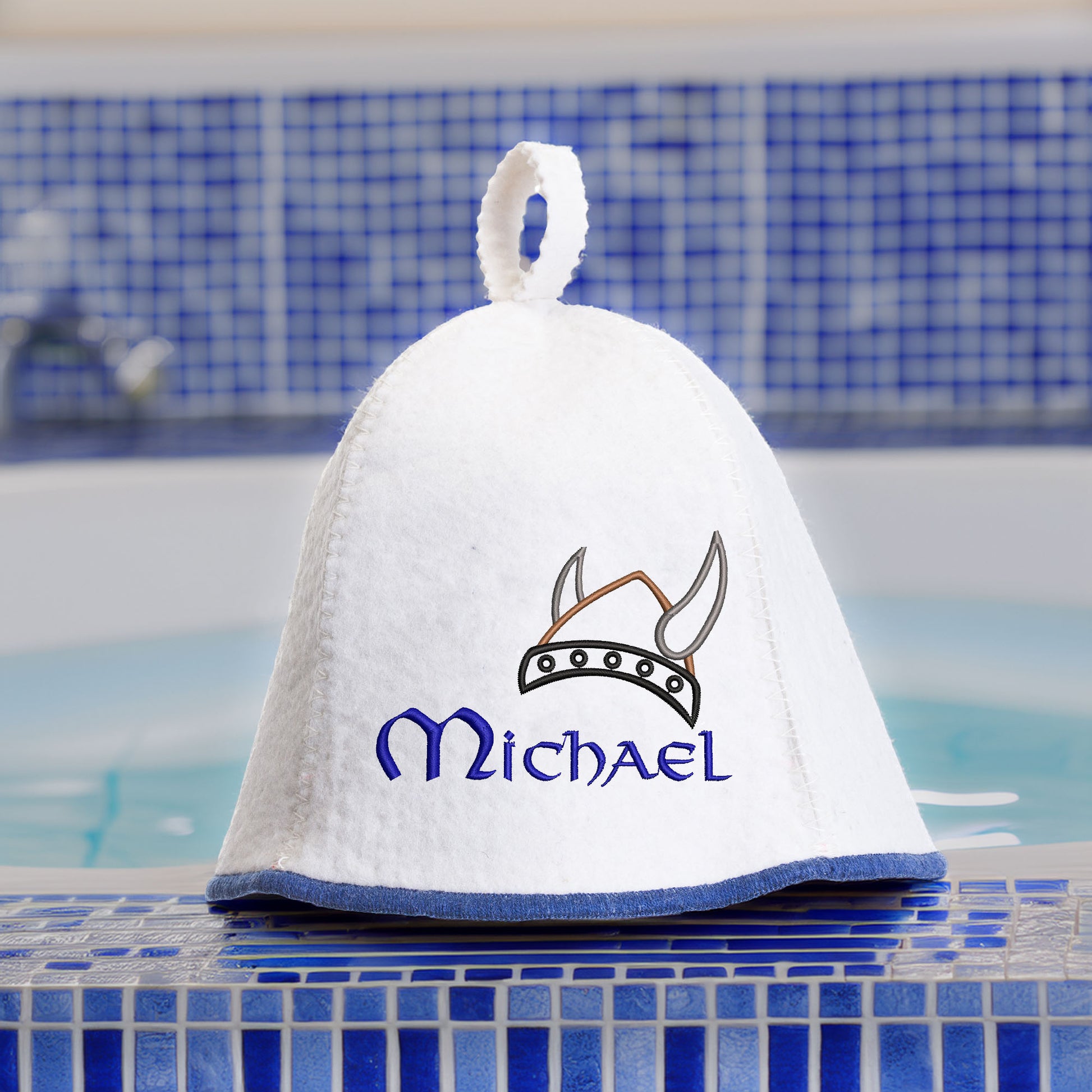 Personalized white felt sauna hat with custom name embroidery near pool