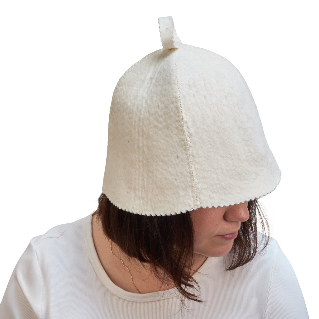 woman wearing a textured white sauna hat against a white background