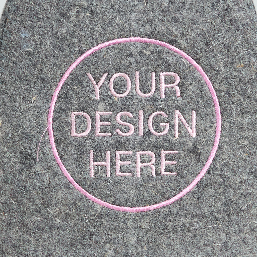 embroidered text 'Your Design Here' on a textured gray felt background