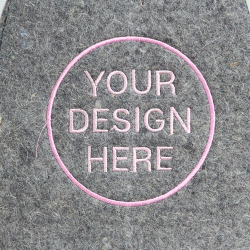 embroidered text 'Your Design Here' on a textured gray felt background
